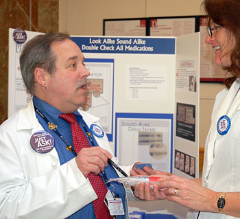 At HUP's 2010 Patient Safety Fair, pharmacist Wayne Marquardt discusses medication safety with a colleague.